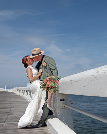 Huwelijksfotografie – speelse sfeerfoto's tijdens trouwdag op staketsel in Oostende